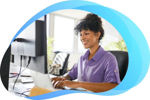 User smiling while working on a laptop, reflecting a positive experience with the system. User smiling while working on a laptop, reflecting a positive experience with the system.